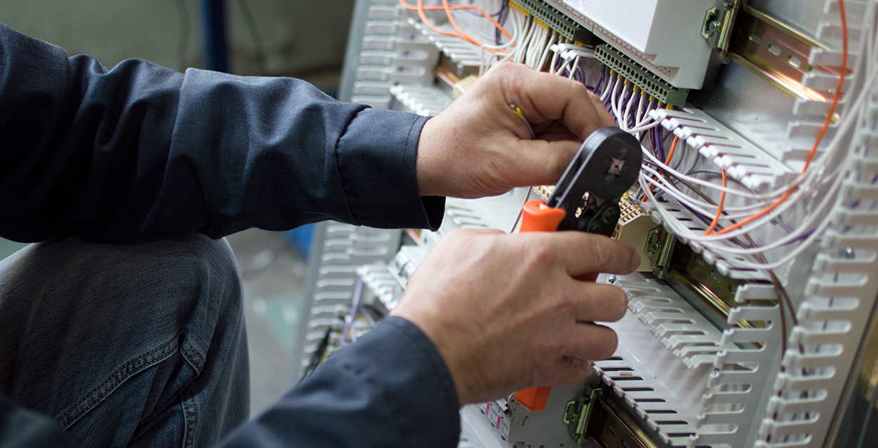 A man performing control panel wiring
