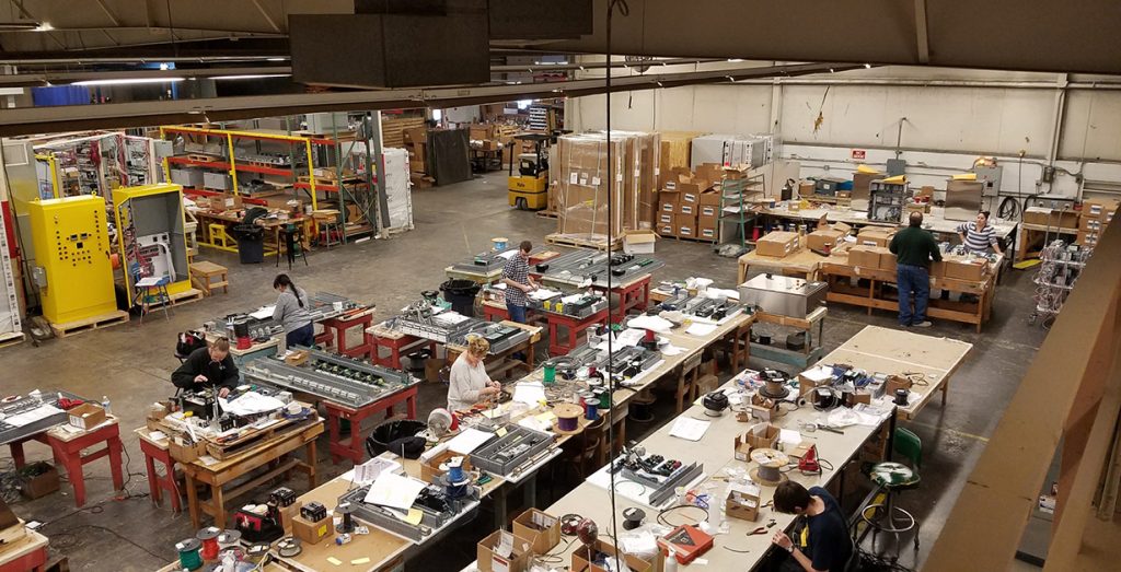 A full team of wiring staff working on control panels